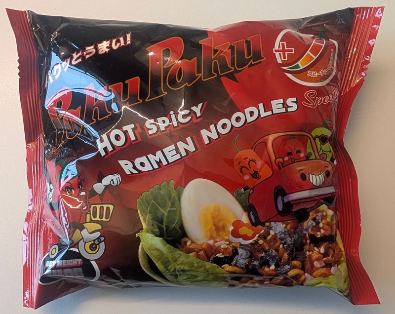 Paku Paku - Speedy Spicy Hot Spicy Ramen Noodles: rote Packung mit rotem Chili-Schriftzug und Nudeln auf dem Etikett
